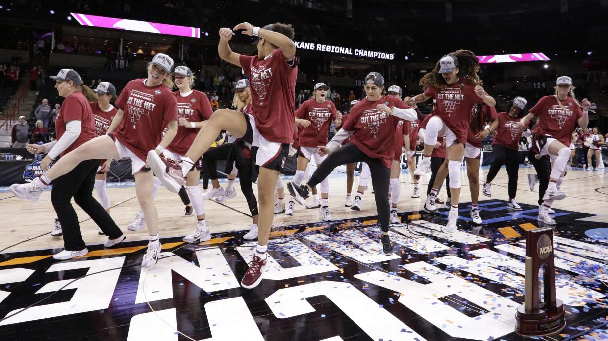 Stanford head coach Tara VanDerveer center, joins her players in a dance behind the regional trophy after they beat Texas 59-50 in a college basketball game in the Elite 8 round of the NCAA tournament, Sunday, March 27, 2022, in Spokane, Wash.