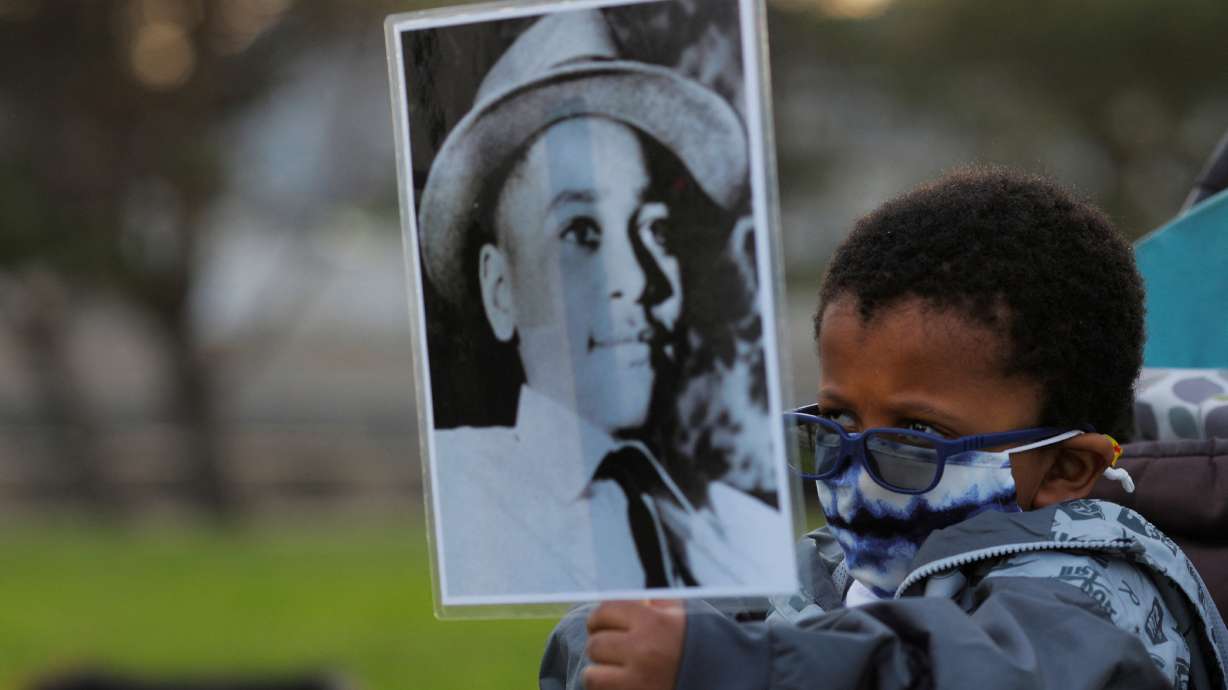 Four-year-old Senty Banutu-Gomez holds a photograph of Emmett Till, a 14-year-old Black boy who was lynched in 1955, at a vigil on the one-year anniversary of the murder of George Floyd while in Minneapolis police custody, in Lynn, Massachusetts, May 25, 2021. President Joe Biden signed a bill Tuesday making lynching a U.S. hate crime.