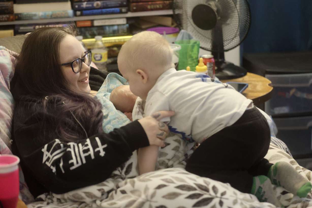 Yvonne Francis, who is recovering from a Cesarean section, holds premature newborn Teagan Francis, as Quintin Francis, 1, climbs on her lap at their home in Salt Lake City on Feb. 11. Her 3-year-old son, Justin Lee Francis, is recovering from COVID-19 after being intubated at Primary Children’s Hospital. Between the premature birth and COVID-19, Yvonne, Teagan and Justin Lee were all hospitalized at the same time.