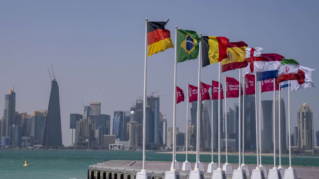 Flags of some of the qualified countries of the World Cup wave at the seafront in Doha, Qatar, Tuesday, March 29, 2022. The draw for the World Cup will be held in Doha on April 1.