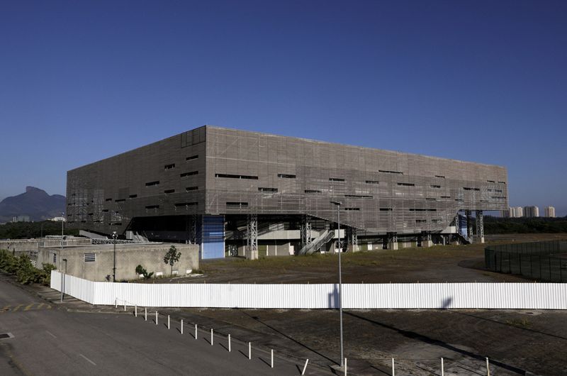 Men work near a facade of the Future Arena, used as a handball venue during the Rio Olympics 2016, now being dismantled to be rebuilt as school buildings, at the Olympic Park in Rio de Janeiro, Brazil March 30, 2022.