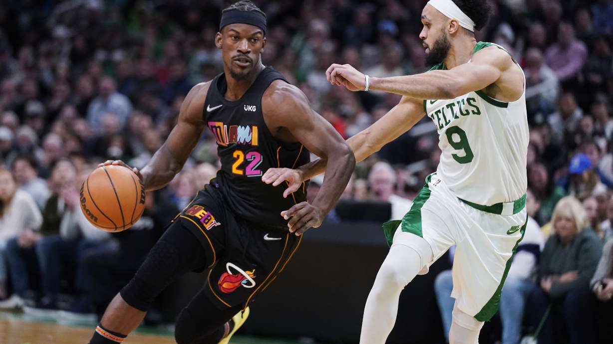 Miami Heat forward Jimmy Butler (22) drives to the basket against Boston Celtics guard Derrick White (9) during the second half of an NBA basketball game Wednesday, March 30, 2022, in Boston.