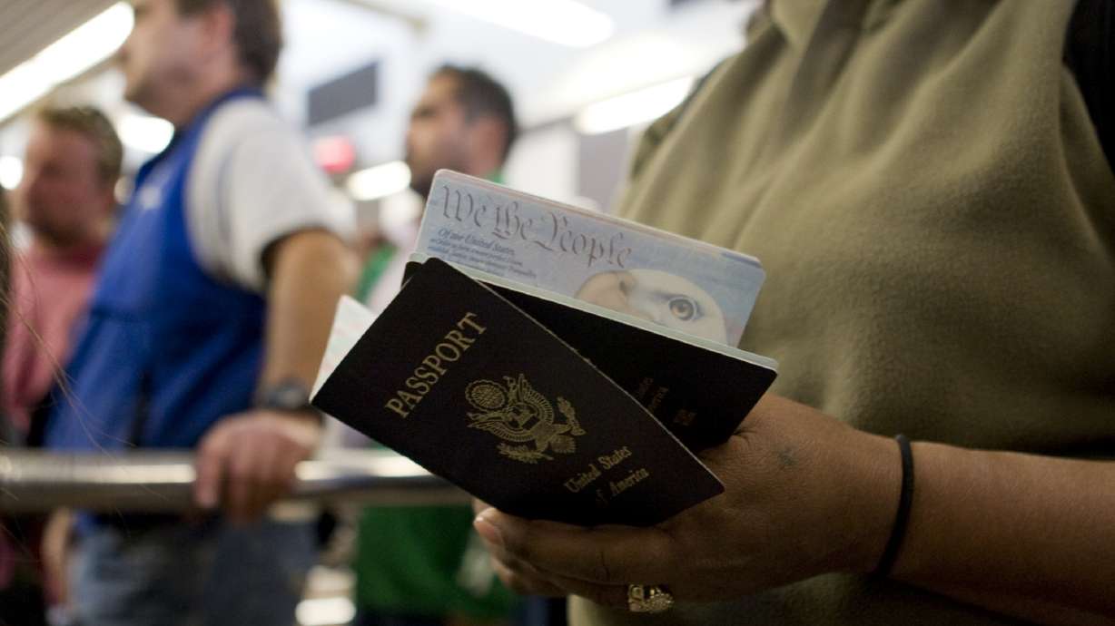 A person holds passports while waiting to cross at the San Ysidro border crossing on January 31, 2008. Americans will be allowed to choose an X for gender on their passport applications and select their sex on Social Security cards, the Biden administration said on Thursday.