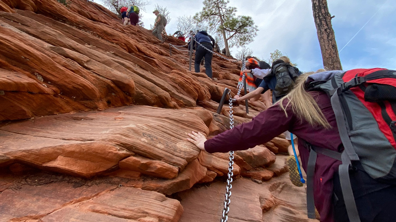 Hikers climb up the chained section of the hike to Angels Landing at Zion National Park on March 26. The park's Angels Landing permit lottery pilot program will remain in place through at least February 2024, following a "successful" debut, park officials say.