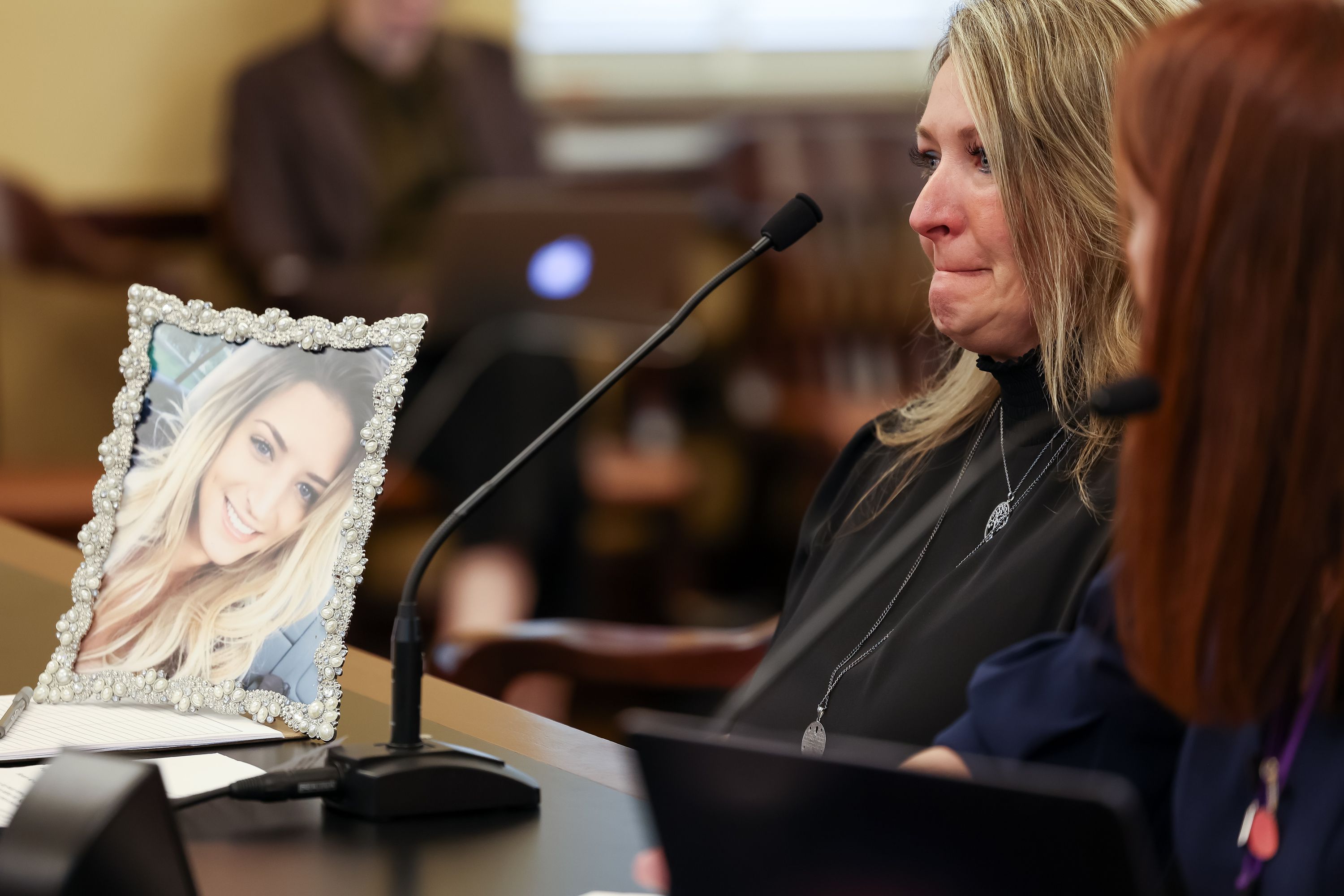 Tammy Allred testifies in favor of HB74 with a portrait of her daughter, Kylie Kaplanis, beside her in the House Health and Human Services Standing Committee at the Capitol in Salt Lake City on Feb. 15. The bill, which would legalize certain patients with terminal illnesses to obtain a prescription for aid in dying, was defeated in committee. Kaplanis was diagnosed with Lou Gehrig’s disease and died at age 27. Terminally ill Utahns may now have easier access to physician-assisted suicide after the in-state residency requirement was abandoned for Oregon’s Death with Dignity Act.