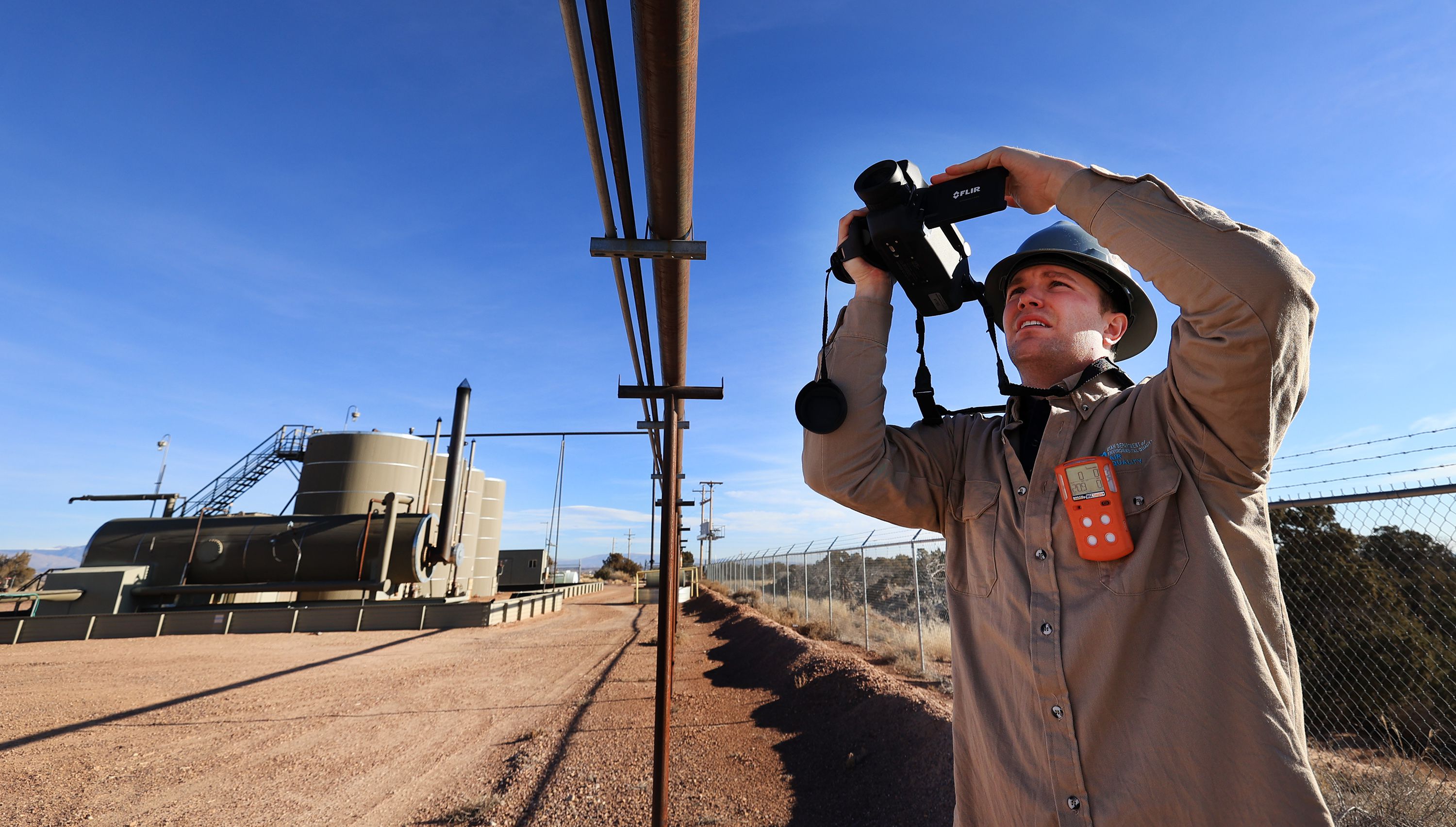 Stephen Foulger, an environmental scientist with the Utah Department of Environmental Quality, uses a Flir gas detection camera to look at welded joints on a pipeline during an inspection of an oil pump site near Roosevelt on Dec. 1, 2021.