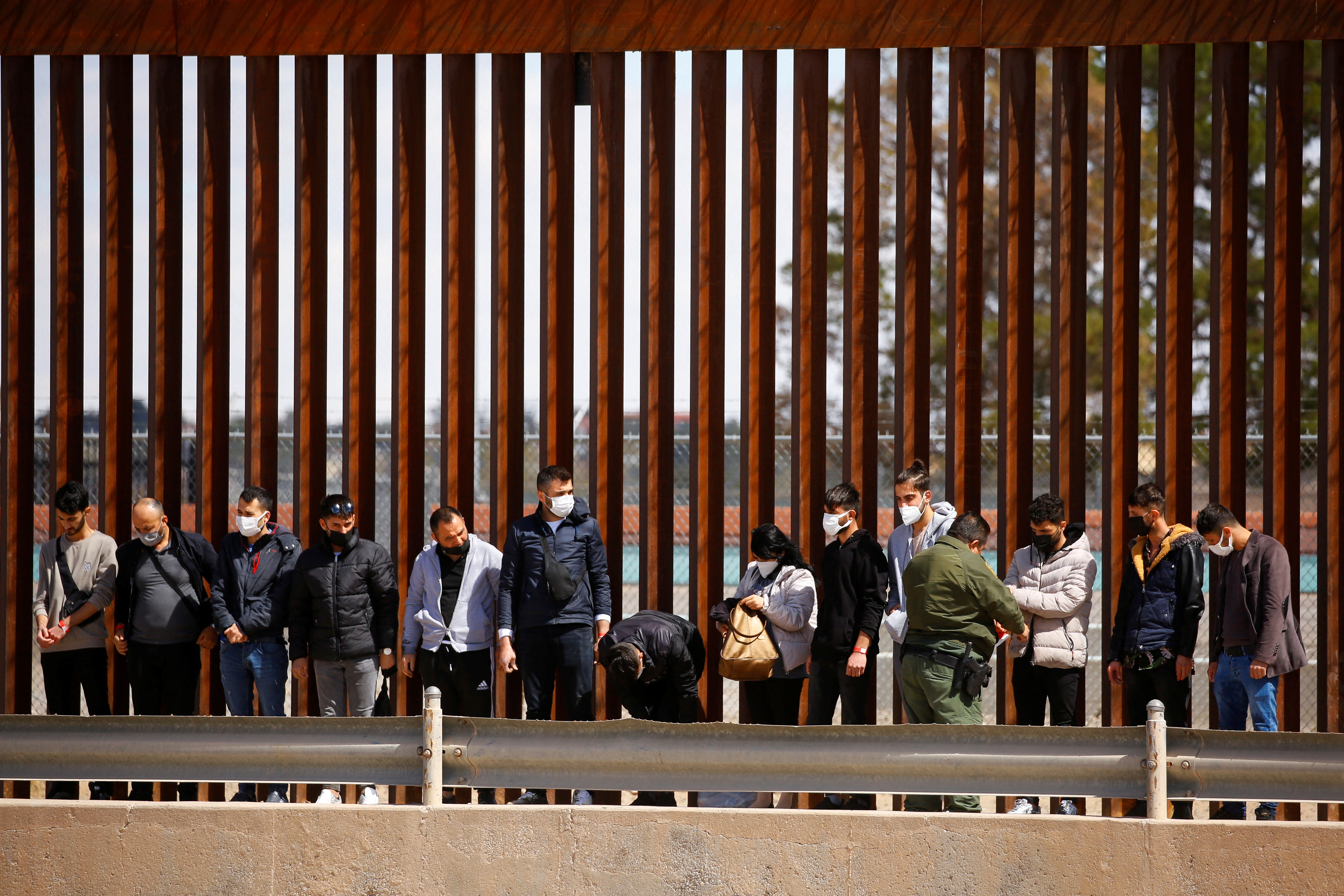 Asylum-seeking migrants are detained by a U.S. Border Patrol agent after crossing the Rio Bravo river to turn themselves in to request asylum in El Paso, Texas, on Thursday. The U.S. will end a sweeping, pandemic-related expulsion policy that has effectively closed down the asylum system at the border with Mexico, Homeland Security said on Friday.
