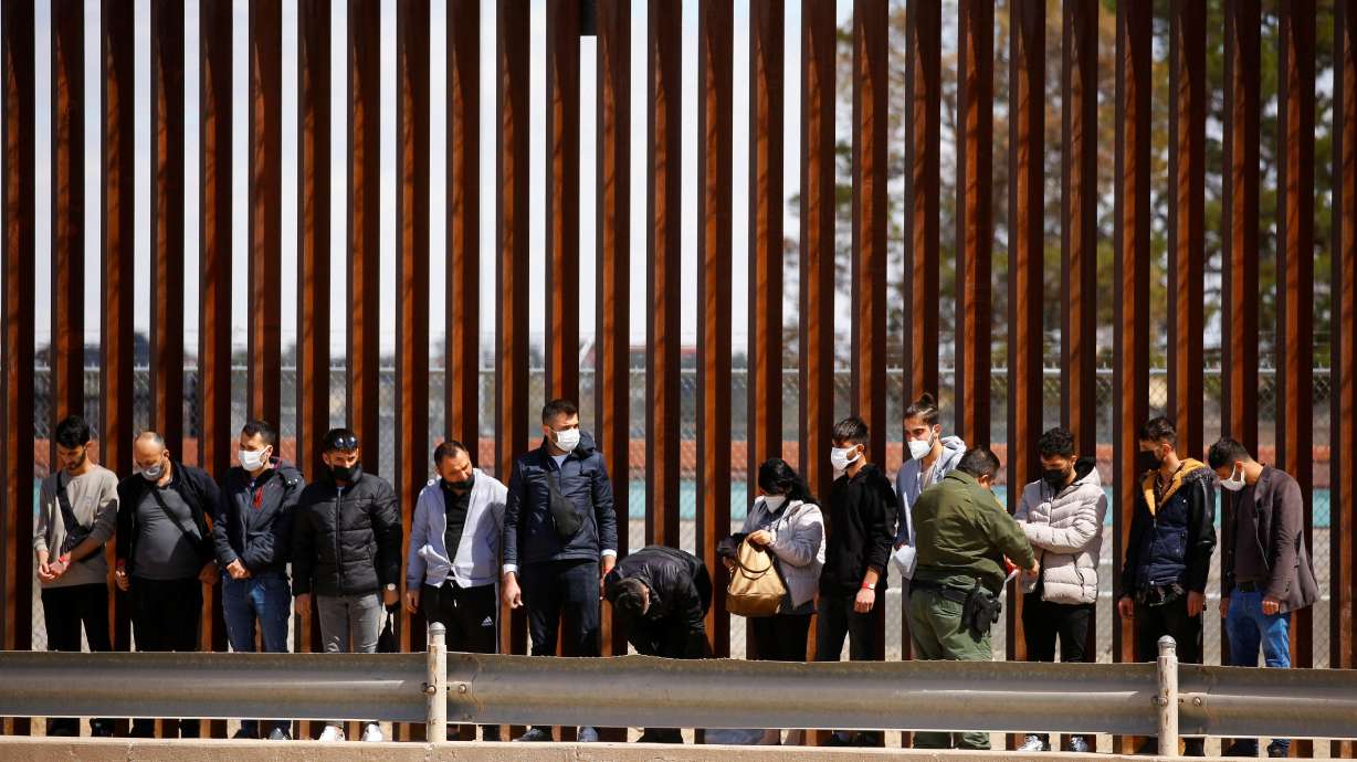 Asylum-seeking migrants are detained by a U.S. Border Patrol agent after crossing the Rio Bravo river to turn themselves in to request asylum in El Paso, Texas, on Thursday. The U.S. will end a sweeping, pandemic-related expulsion policy that has effectively closed down the asylum system at the border with Mexico, Homeland Security said on Friday.