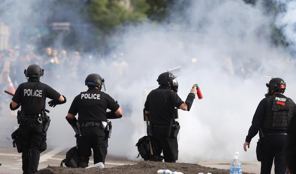 Denver police move during a protest outside the State Capitol over the death of George Floyd, May 30, 2020, in Denver. A federal jury’s $14 million award to Denver protesters injured during 2020 demonstrations over the killing of George Floyd could resonate nationwide as courts weigh more than two dozen similar lawsuits.