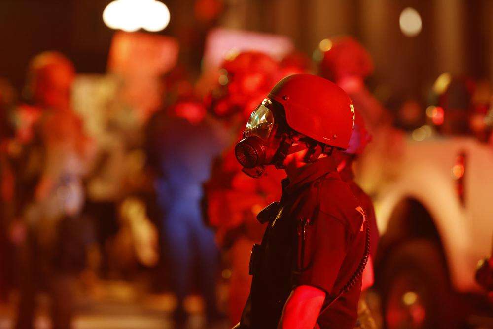 A Denver police officer wears a gas mask before tear gas and rubber bullets were used to disperse protesters outside the State Capitol over the death of George Floyd, May 28, 2020, in Denver.