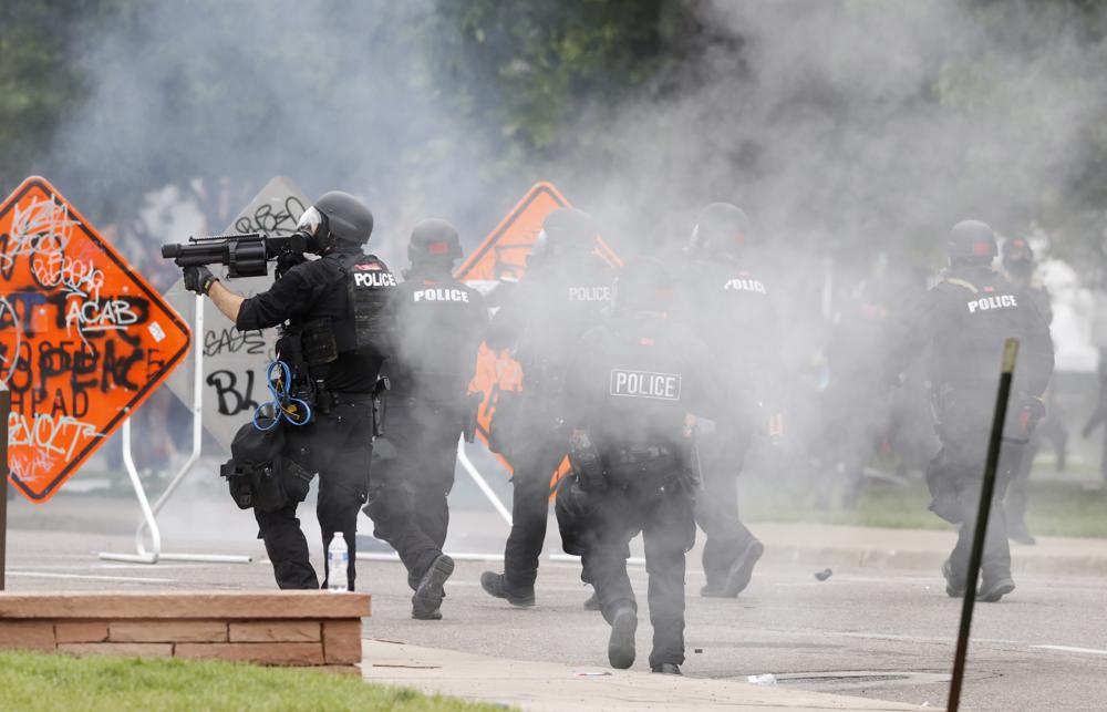Denver police fire tear gas canisters during a protest outside the State Capitol over the death of George Floyd, May 30, 2020, in Denver. A federal jury’s $14 million award to Denver protesters injured during 2020 demonstrations over the killing of George Floyd could resonate nationwide as courts weigh more than two dozen similar lawsuits.