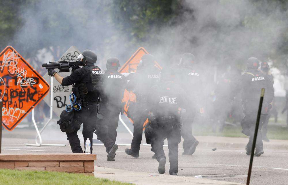 Denver police fire tear gas canisters during a protest outside the State Capitol over the death of George Floyd, May 30, 2020, in Denver. A federal jury’s $14 million award to Denver protesters injured during 2020 demonstrations over the killing of George Floyd could resonate nationwide as courts weigh more than two dozen similar lawsuits.