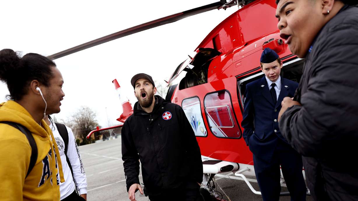 Anesti Ailua, left, a senior at Granger High, and Donavin Nuusila, a junior at Granger, react after Ryan Taul, center, a helicopter mechanic, tells them how much money they can make as a helicopter mechanic as ROTC freshman Zach Carter listens at Utah Rotor Pathway event at Granger High School in West Valley on March 31.