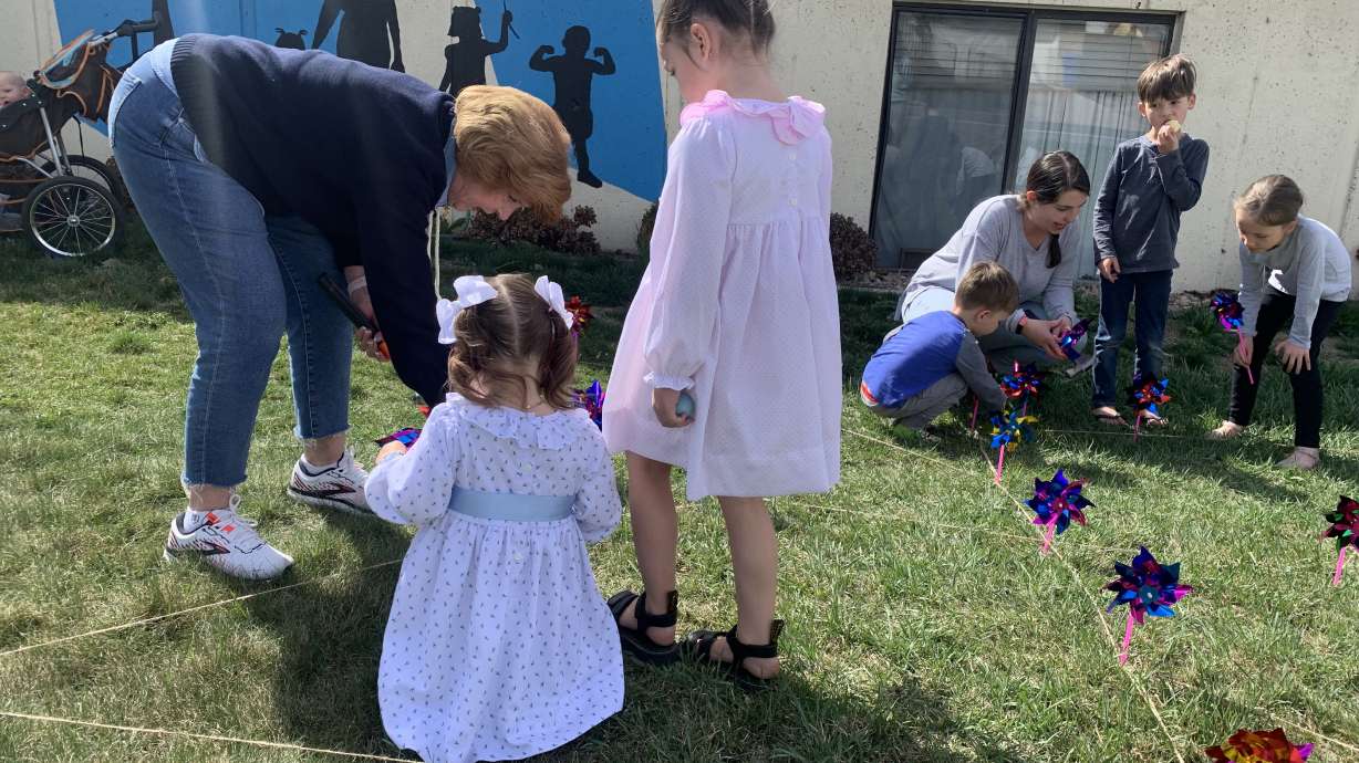 Kay Lindsay helps her great-granddaughters, August Roney and Bailey Clark, place a pinwheel outside Family Haven, 1255 N. 1200 West in Orem, on Friday. The pinwheels are part of the nonprofit organization's celebration of Family Strengthening Month and represent playfulness.
