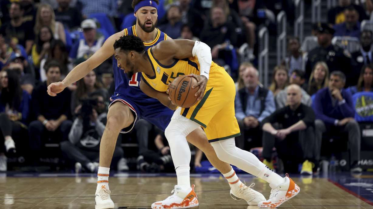 Utah Jazz guard Donovan Mitchell is defended by Golden State Warriors guard Klay Thompson (11) during the first half of an NBA basketball game in San Francisco, Saturday, April 2, 2022.