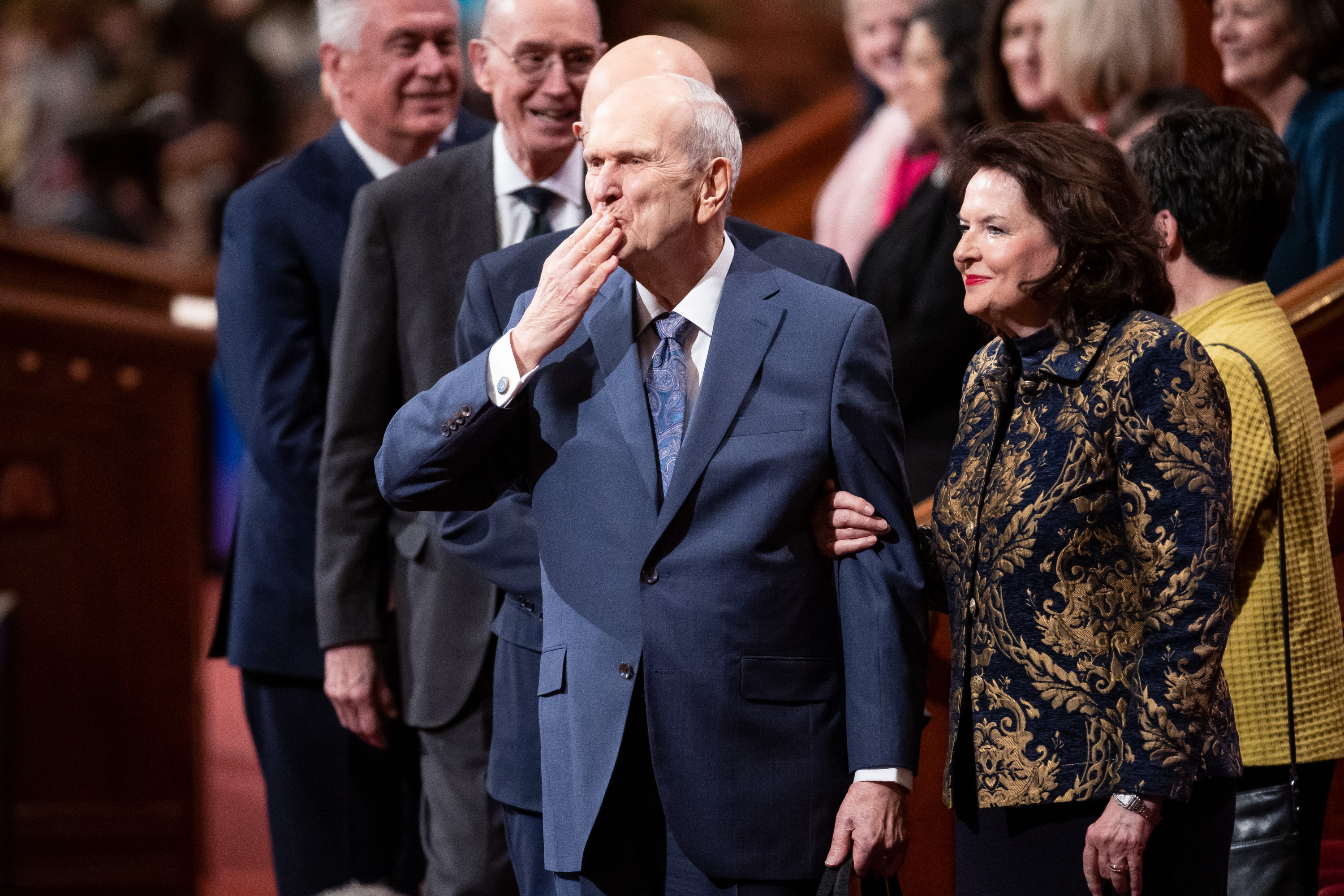 President Russell M. Nelson of The Church of Jesus Christ of Latter-day Saints blows a kiss to attendees as he and his wife, Sister Wendy Nelson, leave at the end of the Saturday evening session of general conference in Salt Lake City.