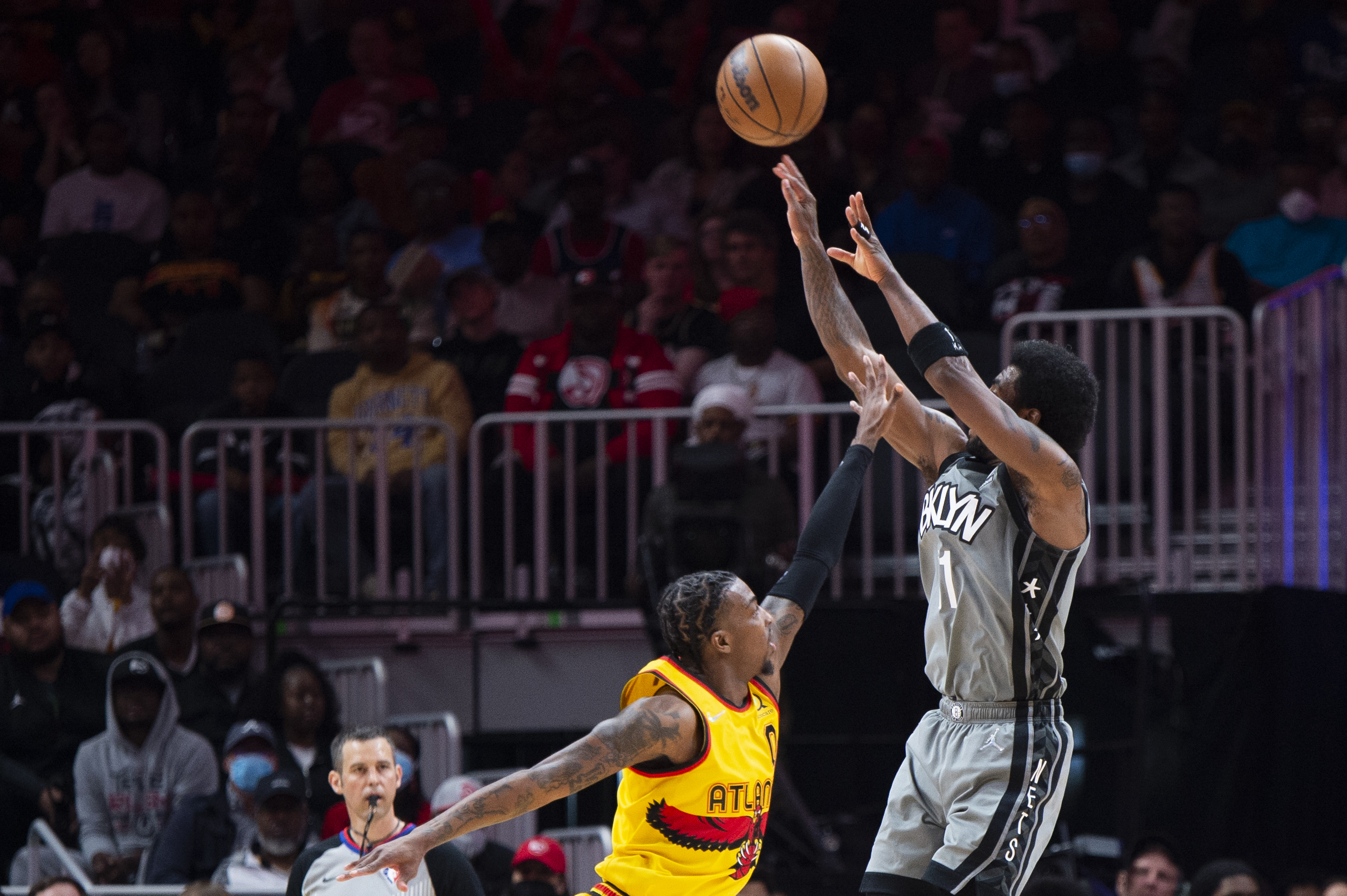 Brooklyn Nets guard Kyrie Irving (11) shoots a 3-point basket over Atlanta Hawks guard Delon Wright (0) during the first half of an NBA basketball game Saturday, April 2, 2022, in Atlanta. 