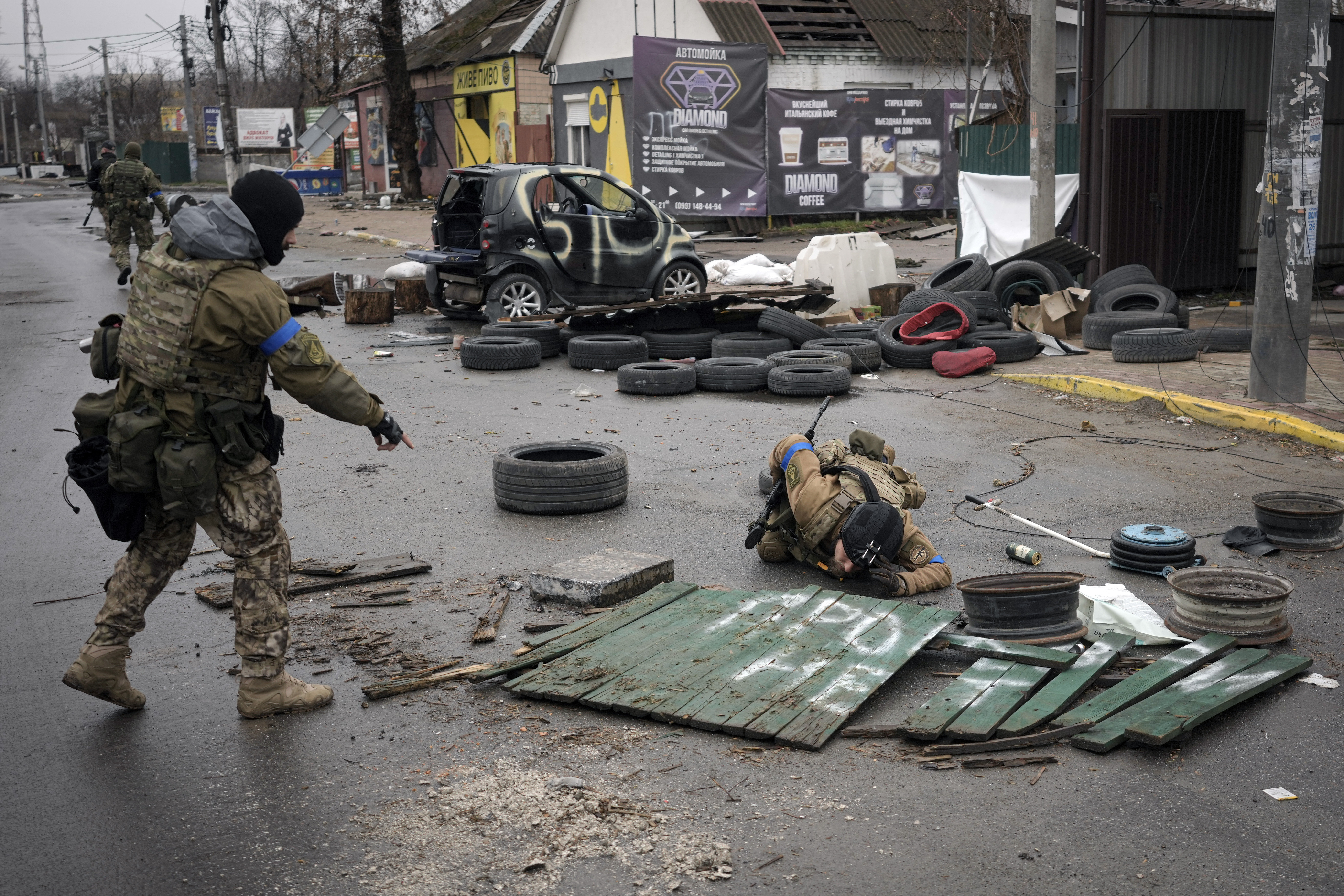 Ukrainian servicemen check streets for booby traps in the formerly Russian-occupied Kyiv suburb of Bucha, Ukraine, Saturday.