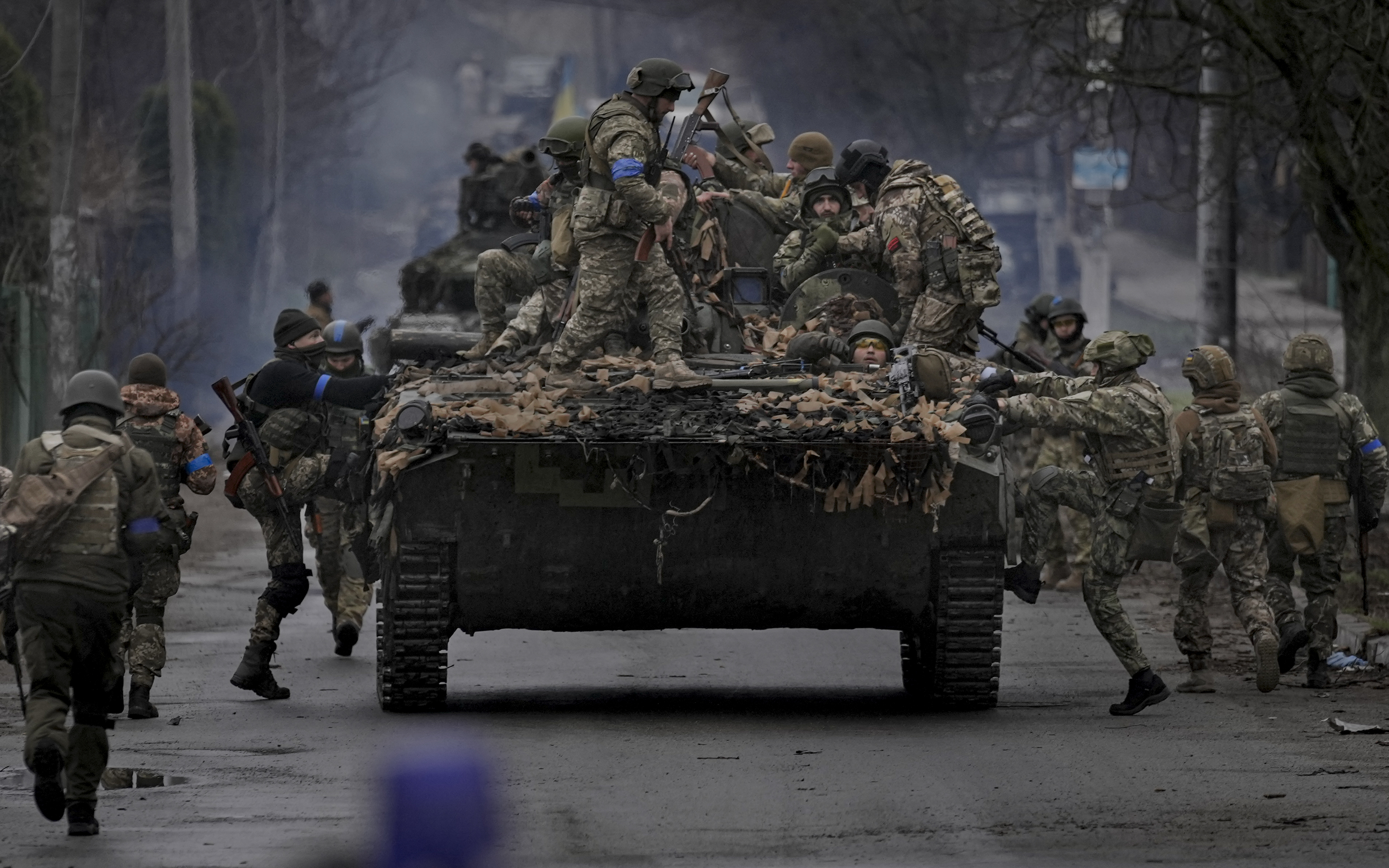 Ukrainian servicemen climb on a fighting vehicle outside Kyiv, Ukraine, Saturday.