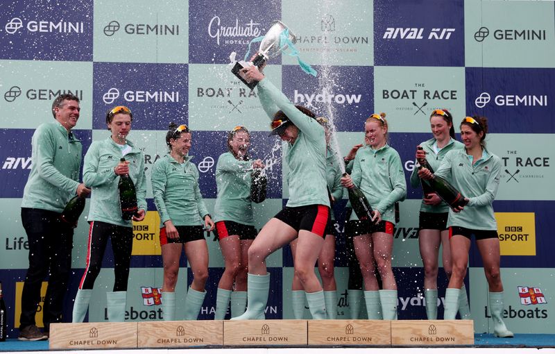 Rowing - University Boat Race - Oxford v Cambridge - River Thames, London, Britain - April 3, 2022 Cambridge's Bronya Sykes lifts the trophy as she celebrates on the podium with teammates after winning the women's boat race Action Images via Reuters/Paul Childs