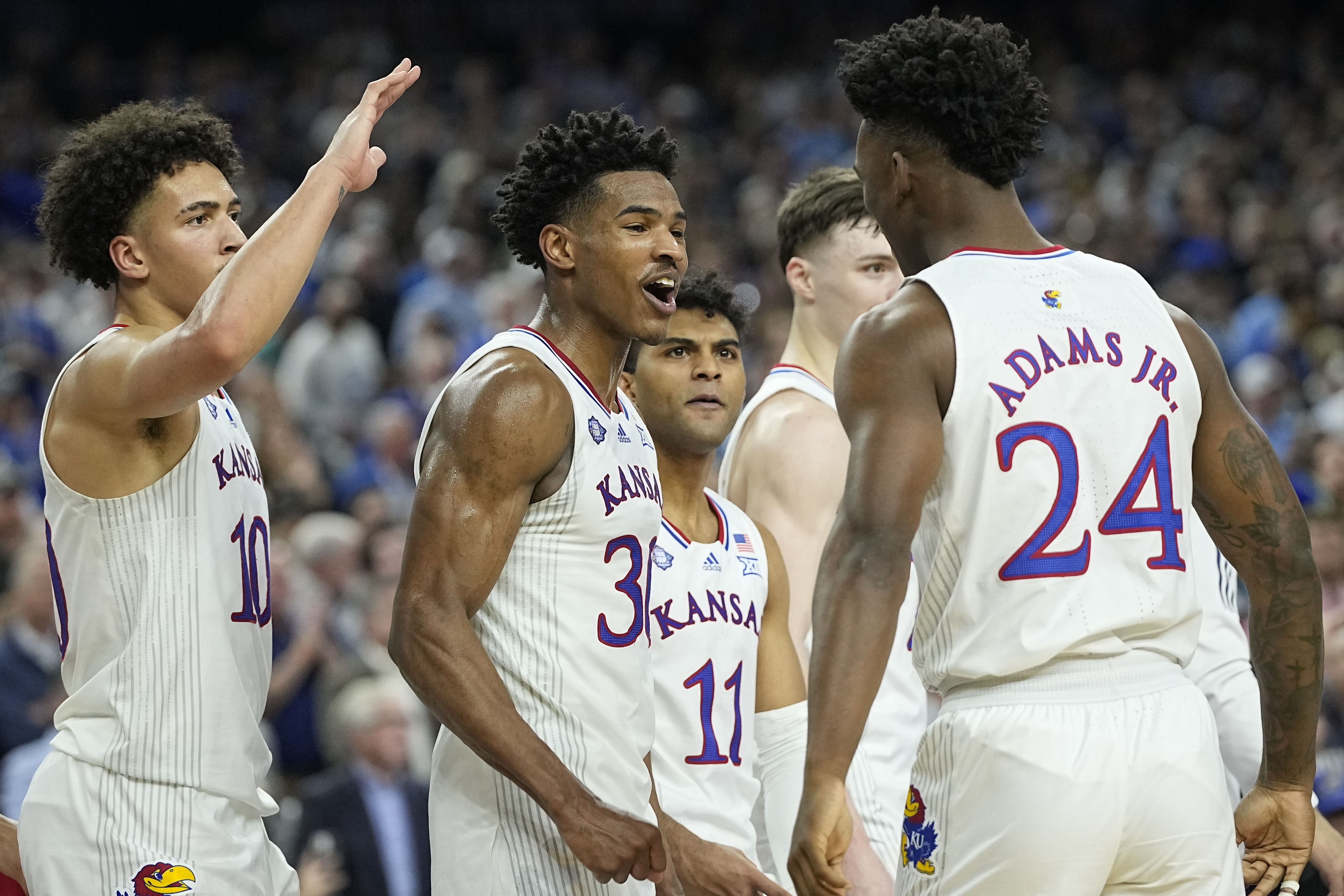 Ochai Agbaji (centro), de Kansas, festeja con sus compañeros Jalen Wilson (10), Remy Martin (11) y K.J. Adams (24) luego de vencer a Villanova en el Final Four, el sábado 2 de abril de 2022, en Nueva Orleáns 