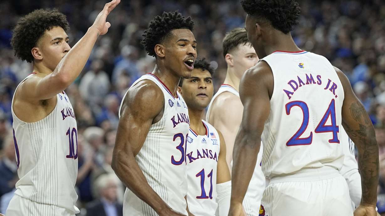Ochai Agbaji (centro), de Kansas, festeja con sus compañeros Jalen Wilson (10), Remy Martin (11) y K.J. Adams (24) luego de vencer a Villanova en el Final Four, el sábado 2 de abril de 2022, en Nueva Orleáns
