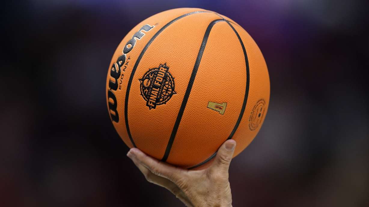 A referee holds up a ball during the second half of a college basketball game in the semifinal round of the Women's Final Four NCAA tournament between South Carolina and Louisville Friday, April 1, 2022, in Minneapolis.