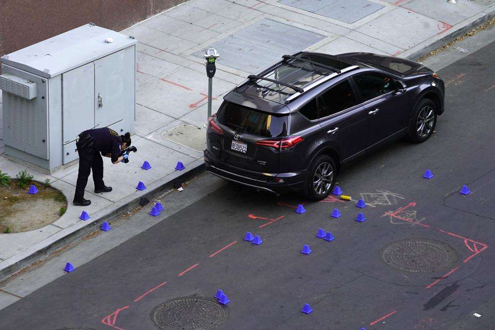 A crime scene investigator photographs evidence markers at the scene of a mass shooting In Sacramento, Calif. on Sunday. Authorities in California’s capital city on Monday identified the six people killed in Sacramento’s mass shooting as police searched for at least two shooters who opened fire in a crowd