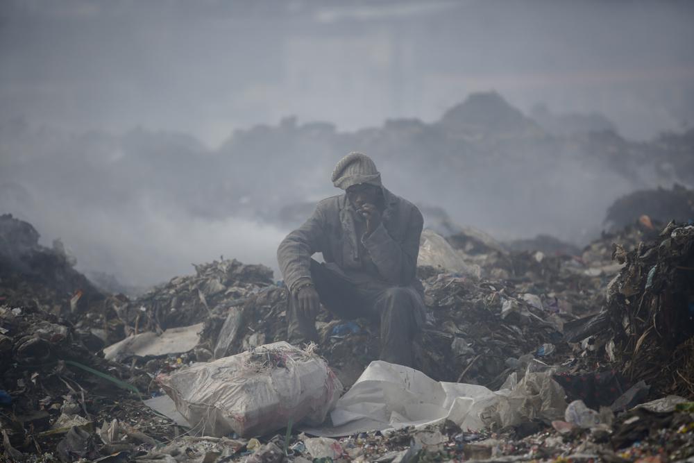 A man scavenges recyclable materials at Dandora, the largest garbage dump in the capital Nairobi, Kenya, Sept. 7, 2021. The U.N. health agency said Monday, nearly everybody in the world breathes air that doesn’t meet its standards for air quality.