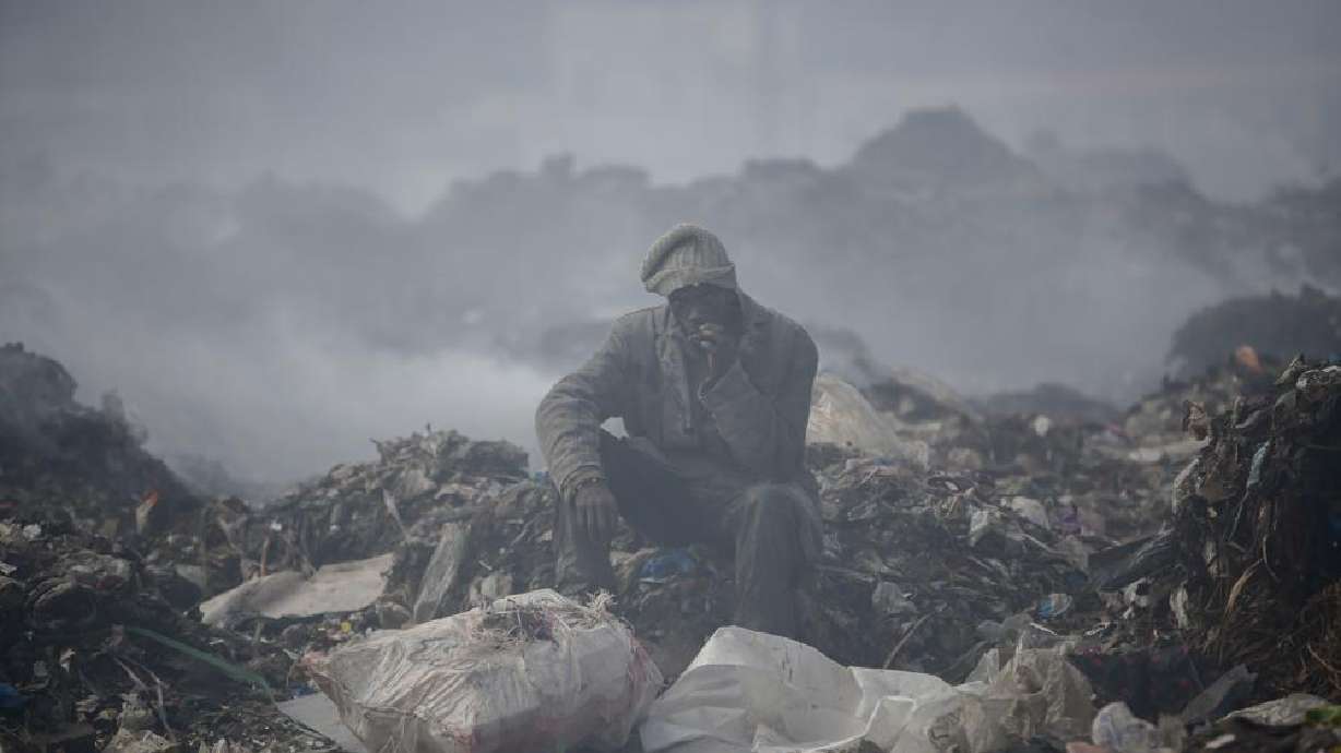 A man scavenges recyclable materials at Dandora, the largest garbage dump in the capital Nairobi, Kenya, Sept. 7, 2021. The U.N. health agency said Monday, nearly everybody in the world breathes air that doesn’t meet its standards for air quality.