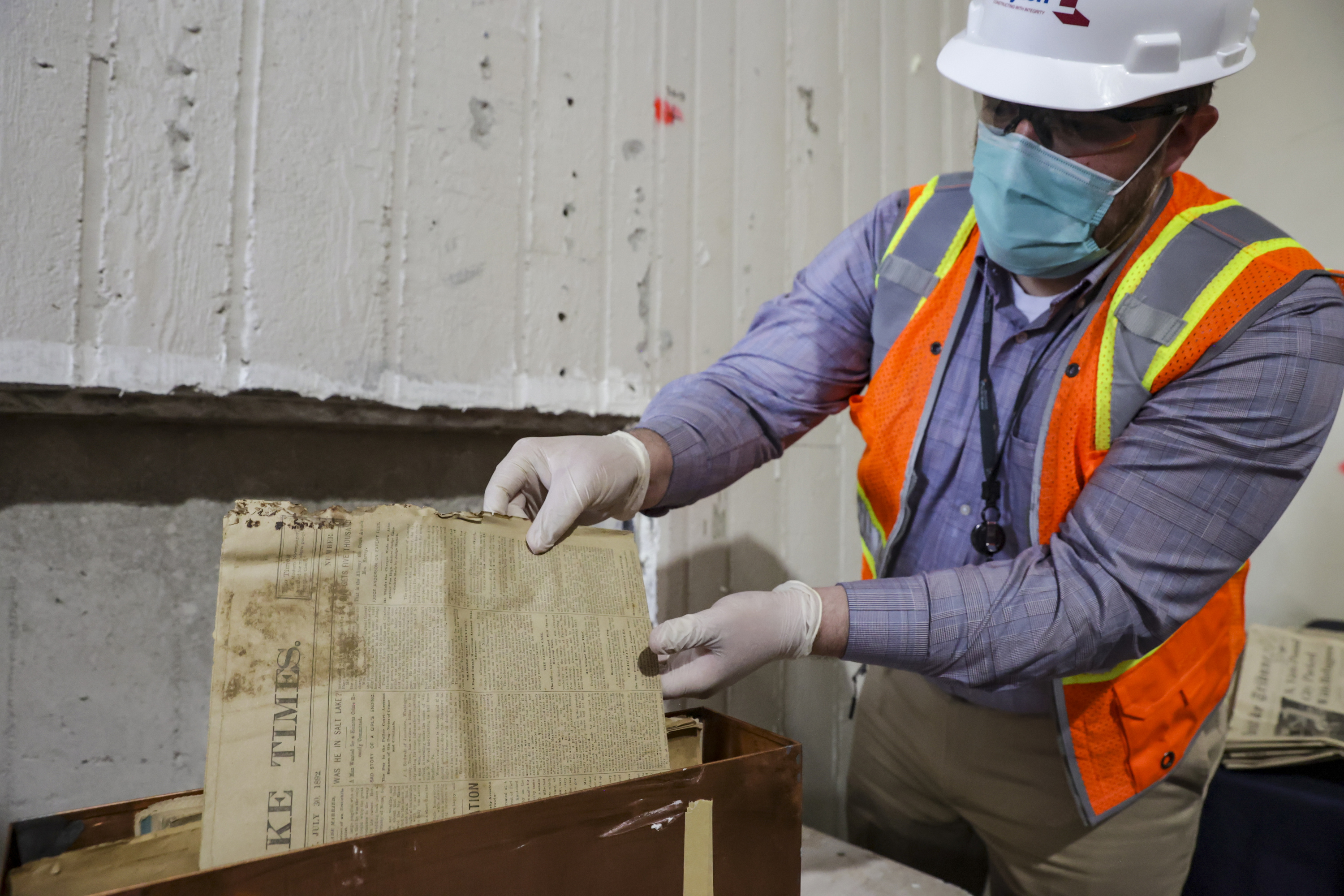 Nathan Miller, director of public relations and communications at St. Mark’s Hospital, removes a copy of the Salt Lake Times from a time capsule at the hospital in Millcreek on Monday. The time capsule was opened to celebrate the hospital's 150th anniversary. 