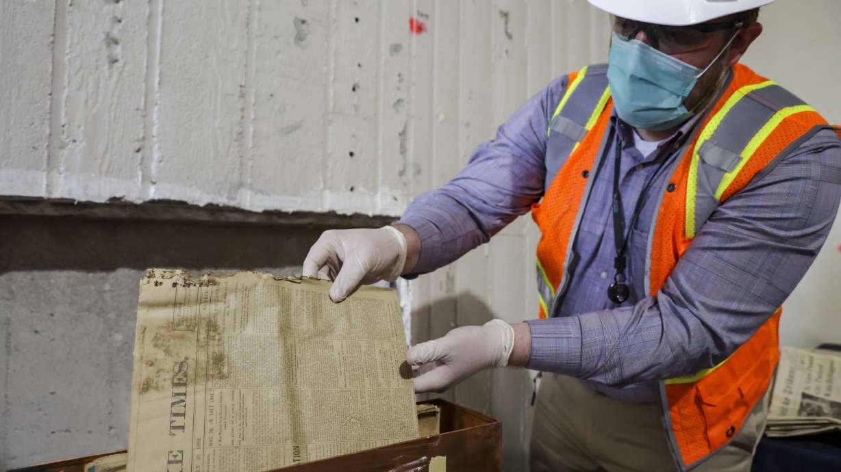 Nathan Miller, director of public relations and communications at St. Mark’s Hospital, removes a copy of the Salt Lake Times from a time capsule at the hospital in Millcreek on Monday. The time capsule was opened to celebrate the hospital's 150th anniversary.