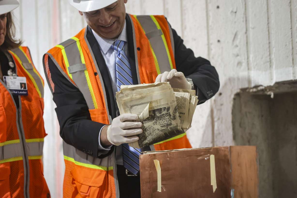 St. Mark’s Hospital CEO Jeremy Bradshaw removes items from a time capsule at St. Mark's Hospital in Millcreek on Monday. The time capsule was opened to celebrate the hospital's 150th anniversary, which is later this month.