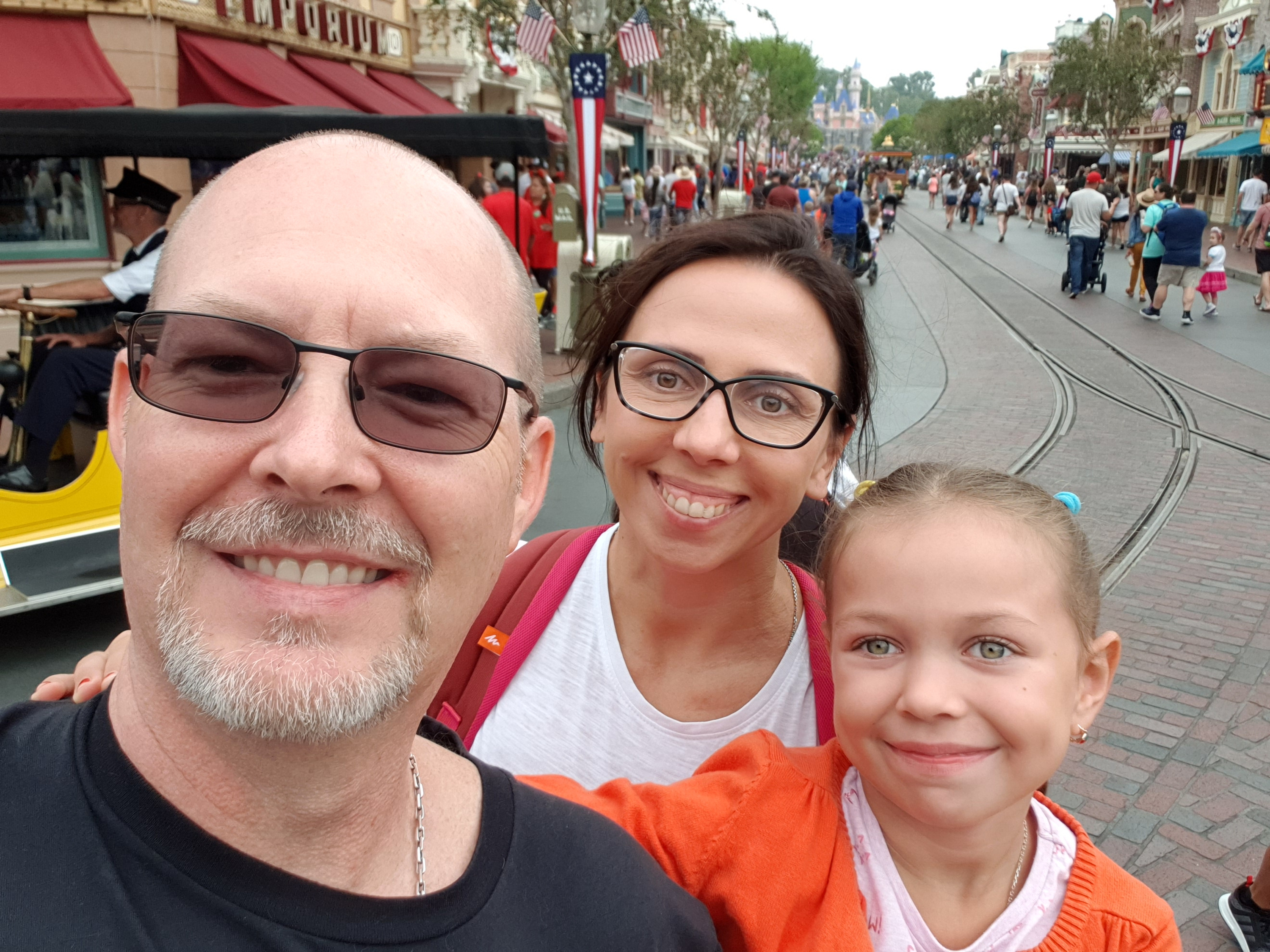 Bradley Harrison, left, his wife, Ganna, and their daughter, Sofia, take a photo together at Disneyland in Anaheim, Calif., on July 13, 2019.