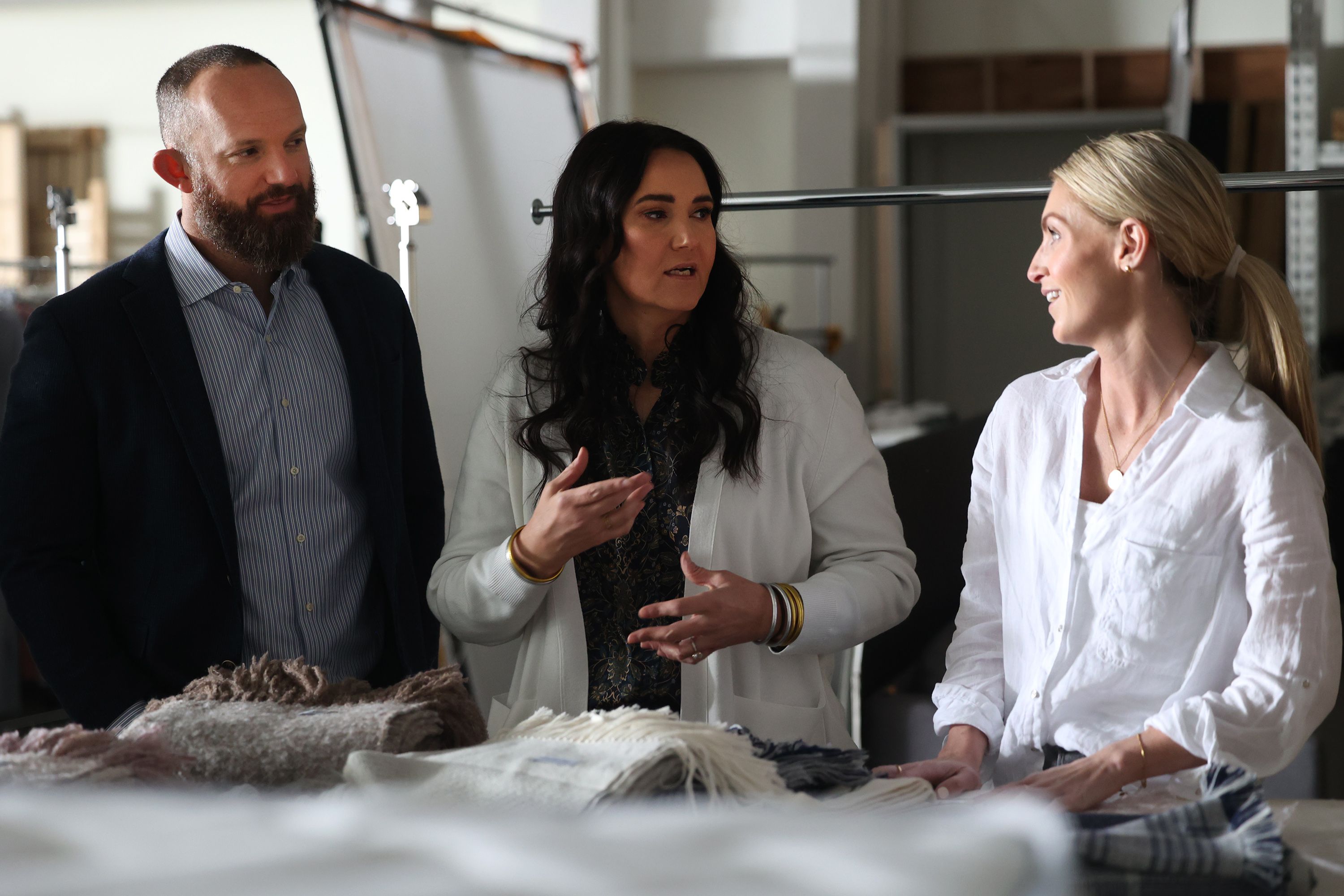Sam and Kacie Malouf stop to talk with Linden Baker, founder of Fairkind, in the photo studio as they show the different sections of their business in Nibley, Cache County, on Tuesday, Jan. 18.