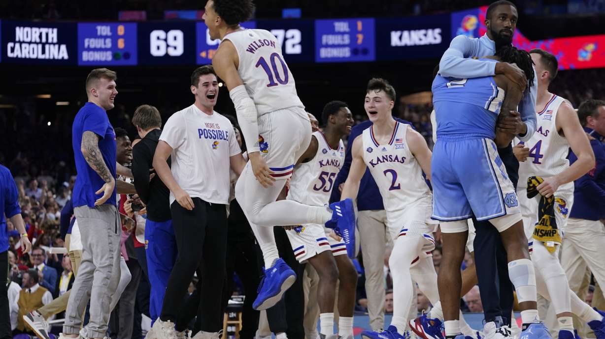 North Carolina guard Caleb Love, right, reacts to a loss as Kansas' Jalen Wilson (10) celebrates after a college basketball game in the finals of the Men's Final Four NCAA tournament, Monday, April 4, 2022, in New Orleans. Kansas won 72-69.