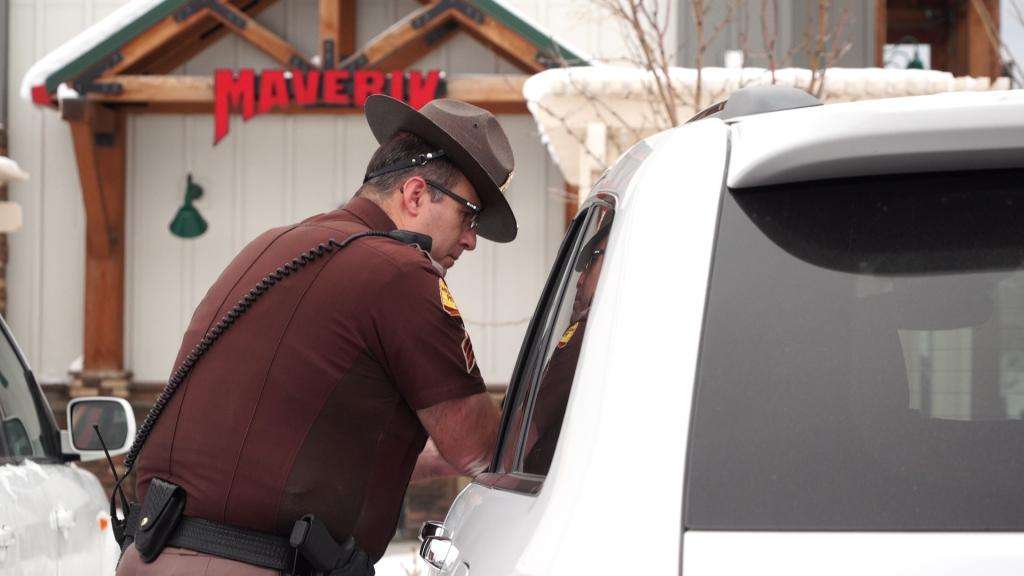 UHP Sgt. Lawrence Hopper issues a ticket to a driver for crossing the HOV lane’s solid, double white line.
