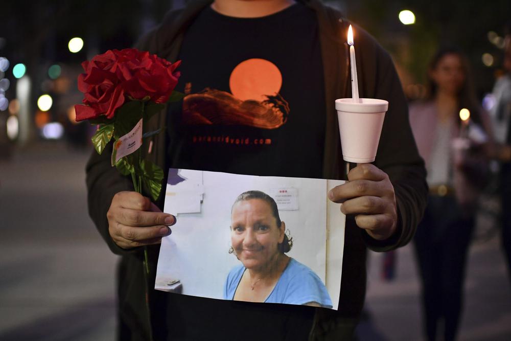 A person who did not want to be identified holds a photograph of Melinda Davis, 57, during a candlelight vigil held at Ali Youssefi Square in Sacramento, Calif., late Monday. Davis was one of the people killed after a shooting that occurred early Sunday.