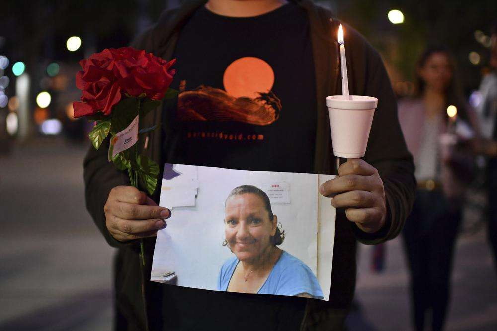 A person who did not want to be identified holds a photograph of Melinda Davis, 57, during a candlelight vigil held at Ali Youssefi Square in Sacramento, Calif., late Monday. Davis was one of the people killed after a shooting that occurred early Sunday.