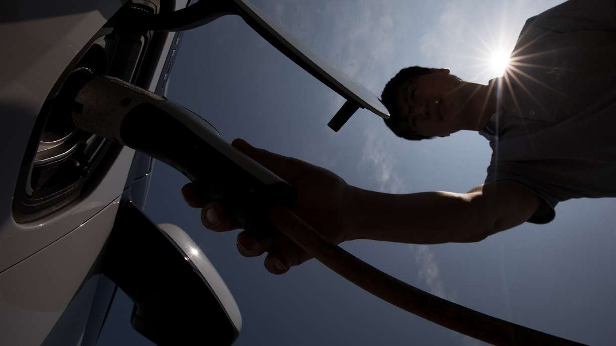 A man charges a hybrid Chevrolet in Jeju, South Korea, in June 2017. The EPA is preparing to release strict new proposed federal emissions standards that would move the U.S. car market decisively toward electric vehicles over the next decade.