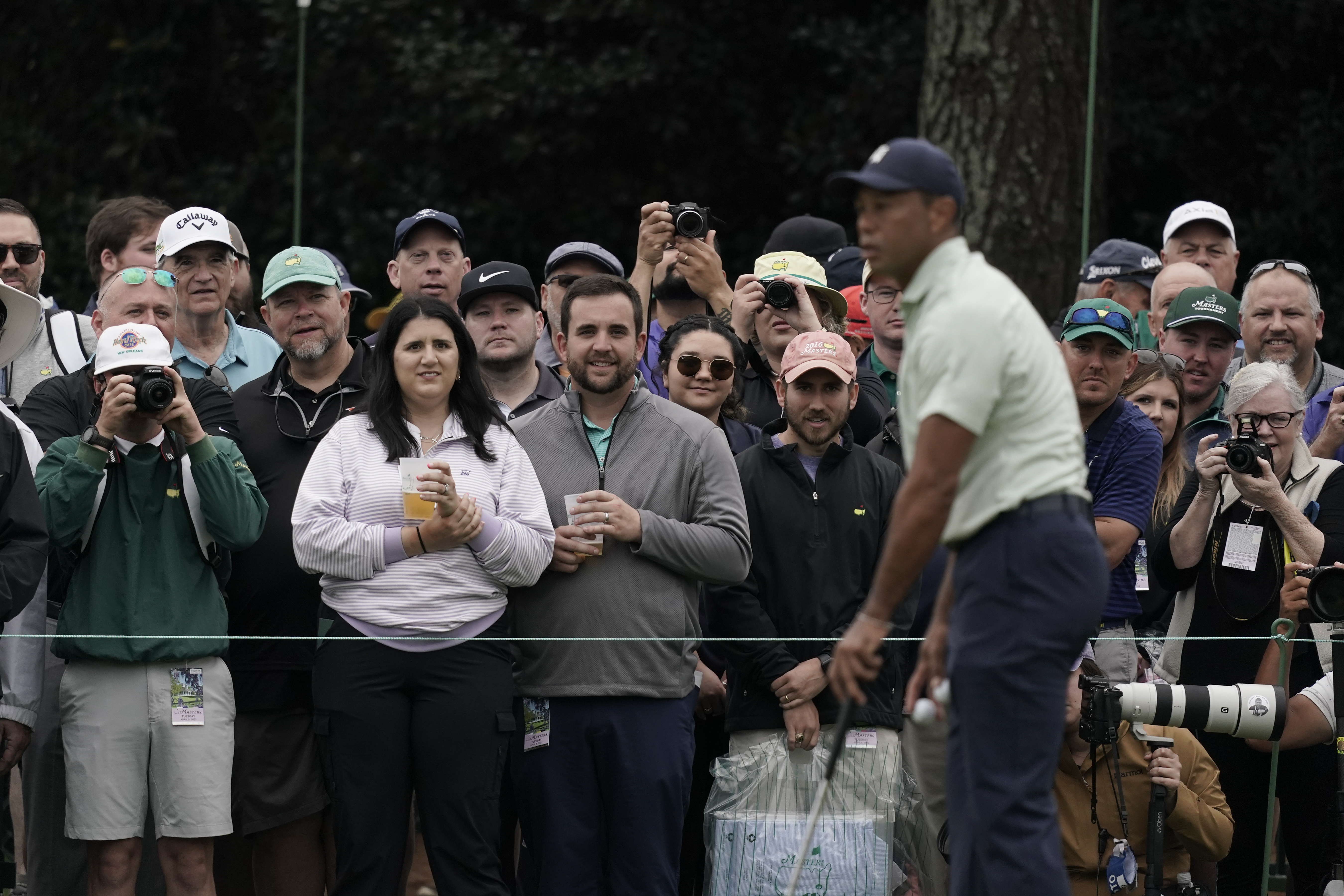 Spectators watch Tiger Woods on the driving range during a practice round for the Masters golf tournament on Tuesday, April 5, 2022, in Augusta, Ga. 