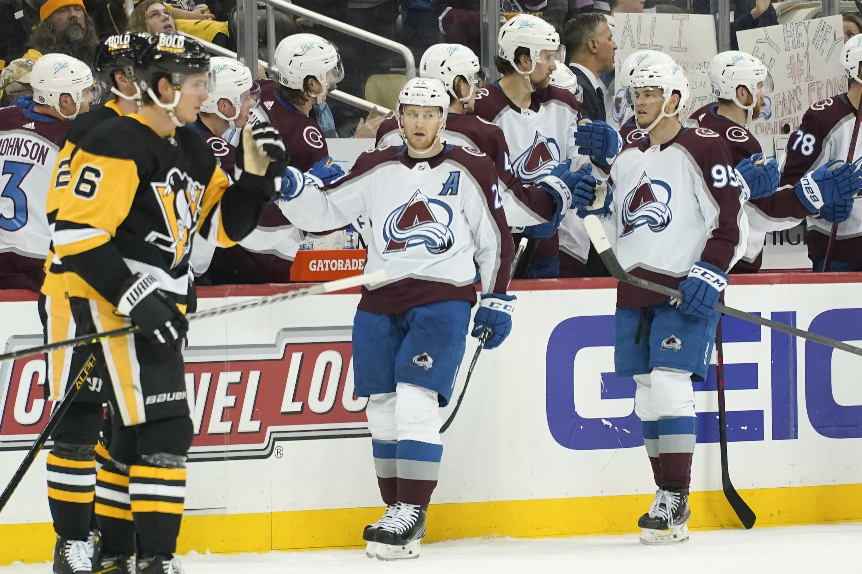 Colorado Avalanche's Nathan MacKinnon, center, celebrates with teammates on the bench after scoring against the Pittsburgh Penguins during the second period of an NHL hockey game, Tuesday, April 5, 2022, in Pittsburgh. 