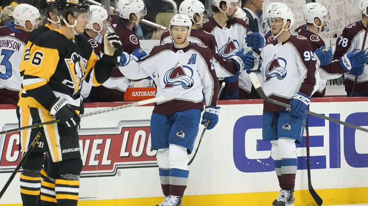 Colorado Avalanche's Nathan MacKinnon, center, celebrates with teammates on the bench after scoring against the Pittsburgh Penguins during the second period of an NHL hockey game, Tuesday, April 5, 2022, in Pittsburgh.