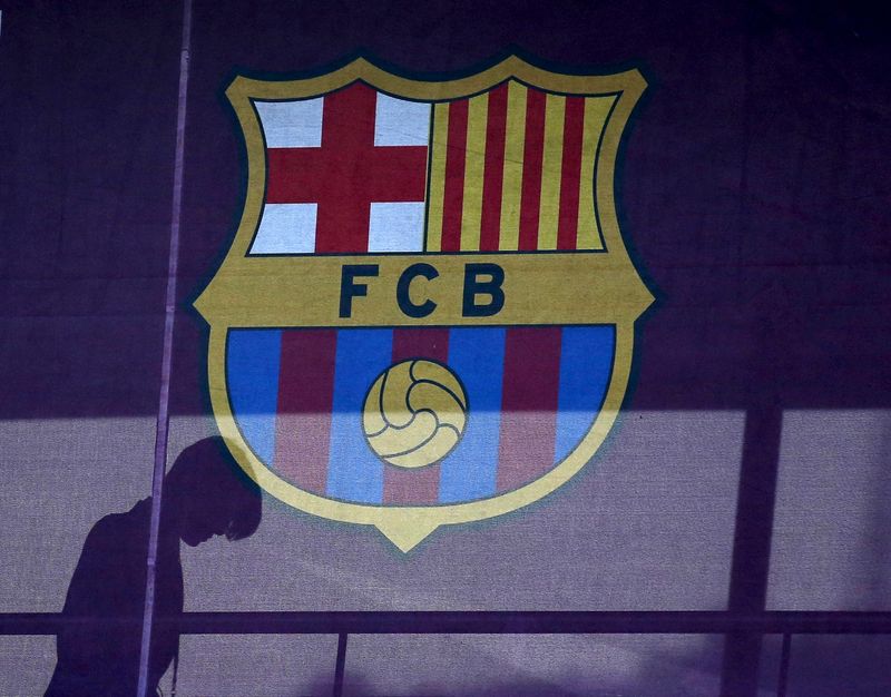 FILE PHOTO: A silhouette of a woman walks past behind a FC Barcelona's logo at Camp Nou stadium in Barcelona, Spain, March 24, 2016.