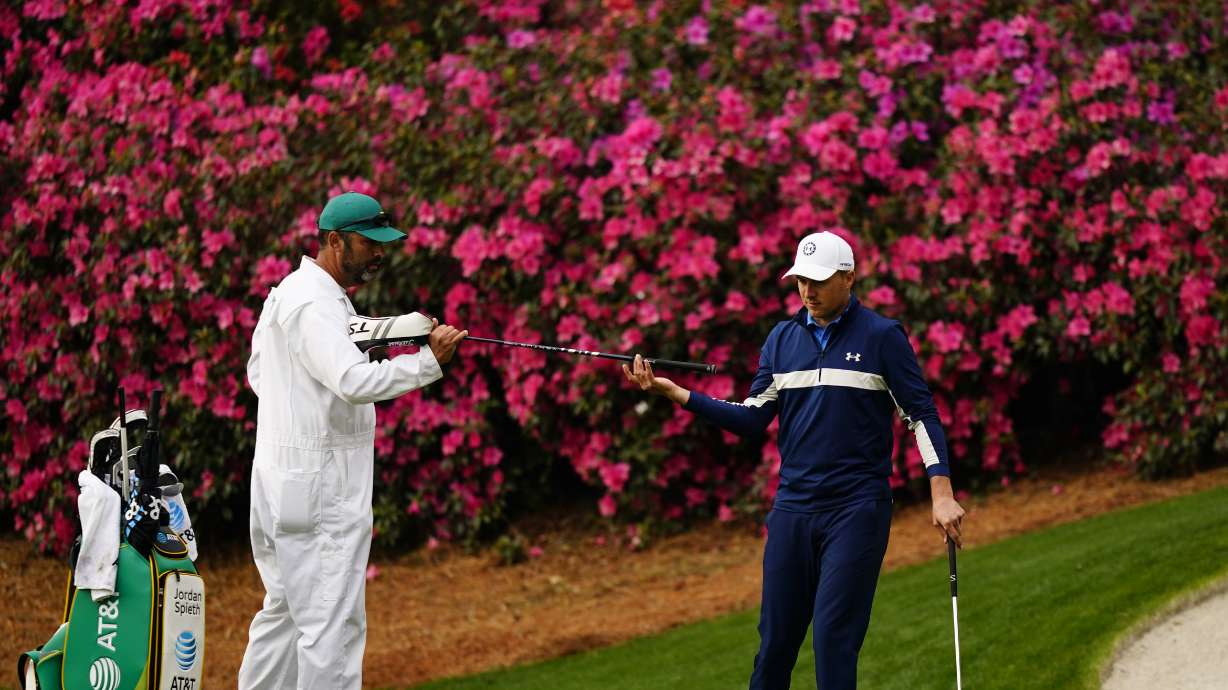 Jordan Spieth gets a club from his caddie on the 13th hole during a practice round for the Masters golf tournament on Tuesday, April 5, 2022, in Augusta, Ga.
