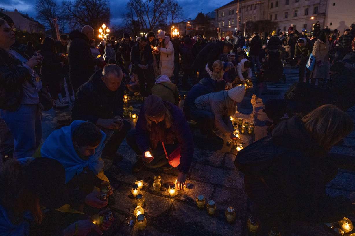 People light candles forming the shape of Ukraine's map, in memory of lost lives, in front of the Taras Shevchenko monument, in Lviv, western Ukraine, Tuesday.