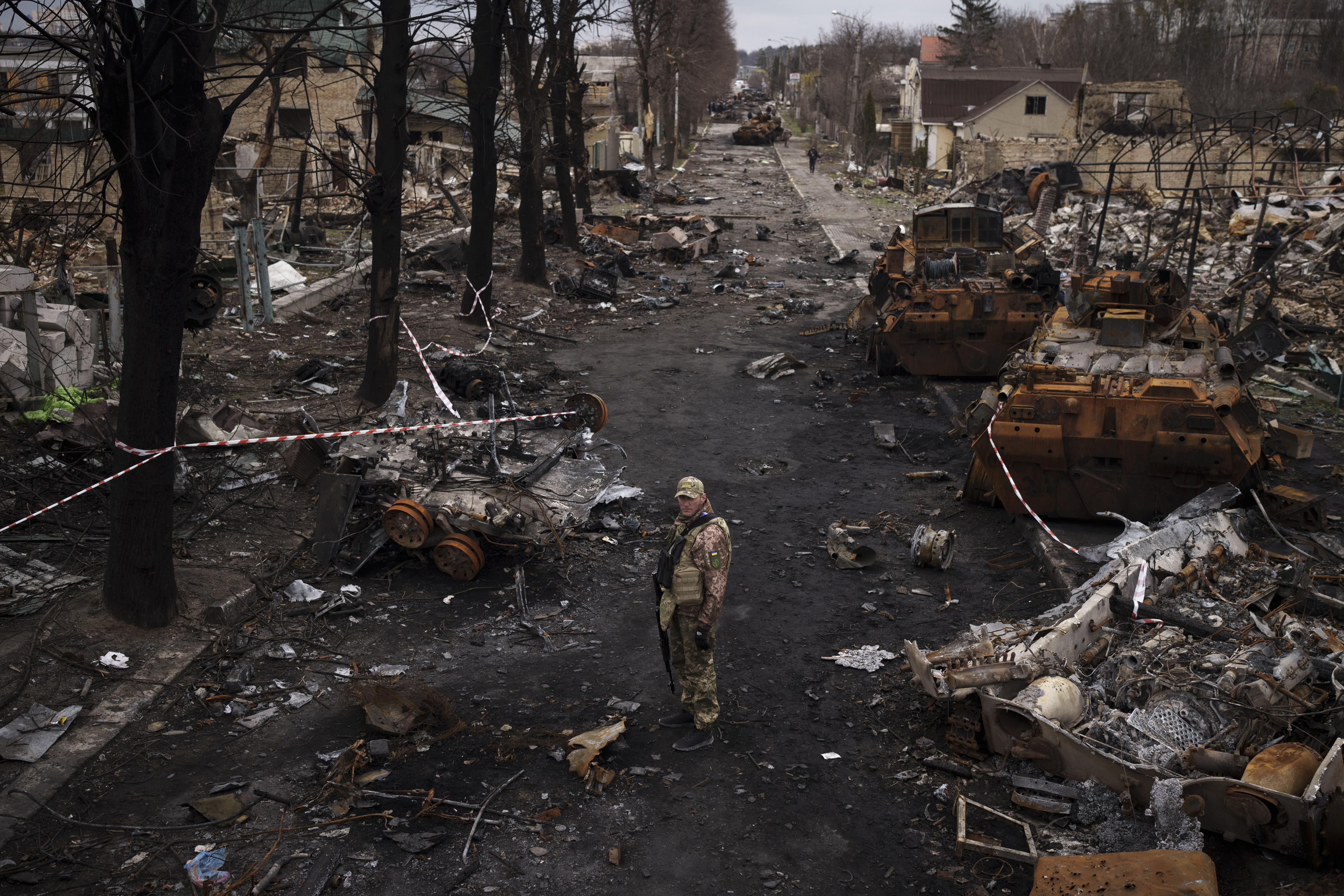 A Ukrainian serviceman stands amid destroyed Russian tanks in Bucha, on the outskirts of Kyiv, Ukraine, Wednesday.