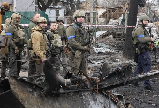 Ukrainian President Volodymyr Zelenskyy, center left, examines the site of a recent battle in Bucha, close to Kyiv, Ukraine, Monday. Russia is facing a fresh wave of condemnation after evidence emerged of what appeared to be deliberate killings of civilians in Ukraine.
