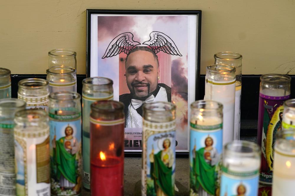 A photo of De'vazia Turner is surrounded by candles, Tuesday, at a memorial near where he was killed in a mass shooting on Sunday in Sacramento, Calif.