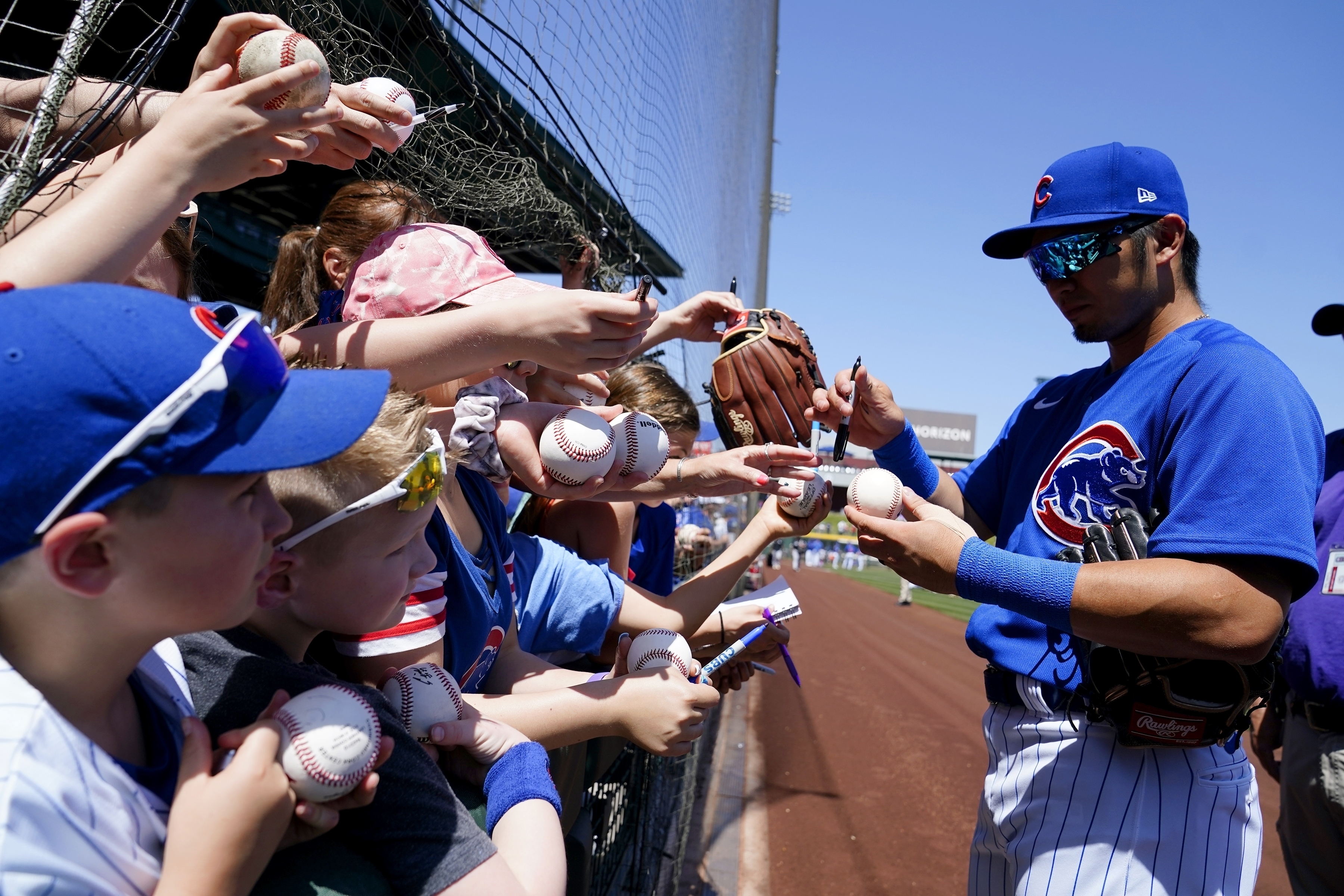 FILE - Chicago Cubs' Seiya Suzuki, of Japan, signs autographs for fans prior to a spring training baseball game against the Chicago White Sox, Monday, April 4, 2022, in Mesa, Ariz. About 1 in 4 fans of Major League Baseball feel at least some anger toward the sport after its first work stoppage in a generation, according to a new poll, but the vast majority are still excited about the new season. Only 27% of Americans say they are currently a fan of MLB, according to the poll from The Associated Press-NORC Center for Public Affairs Research.